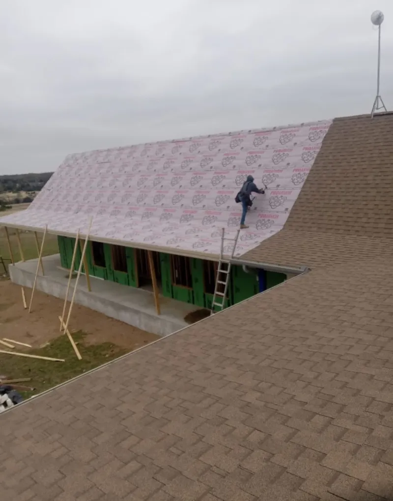 Worker preparing underlayment for a metal roof installation in Morgantown